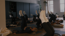 Women in matching navy activewear practicing pilates leg raises on pilates mats in a sleek studio setting.